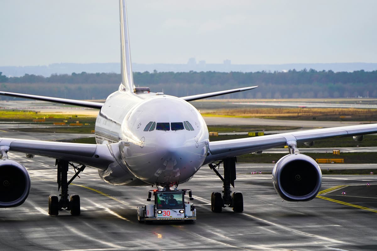 Wide-body aircraft on the apron with a tug